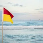 Surfing Safely: Essential Tips for Ocean Safety 5 A red and yellow beach flag, showing where it is safe to enter the ocean