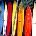 A rack of different types of surfboards