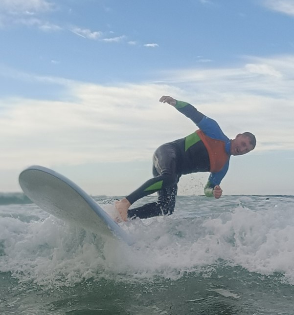 A beginner surfer falling from their surfboard