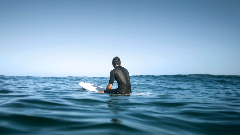 A surfer, alone in the water, looking for a wave