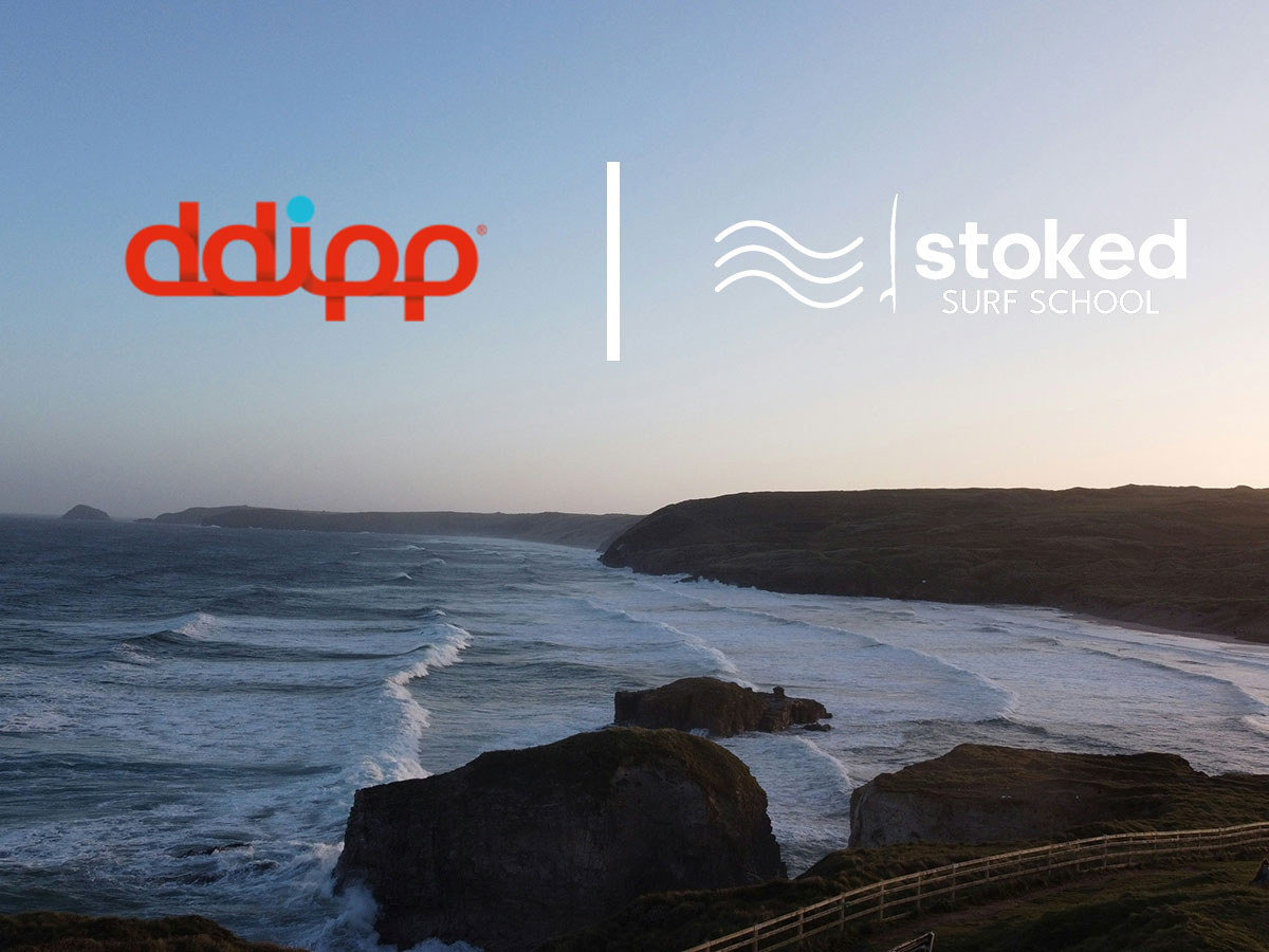 a view of Perranporth beach with the ddipp and Stoked logos above