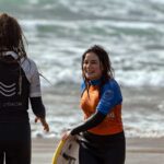 Coach Sasha with a smiling female surf student