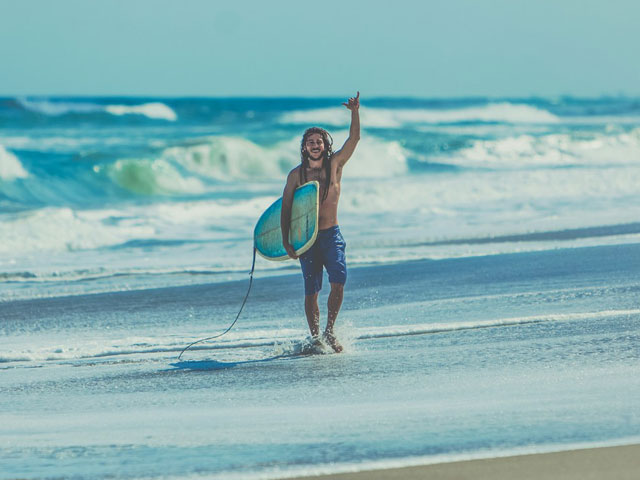 A surfer throwing a shaka sign