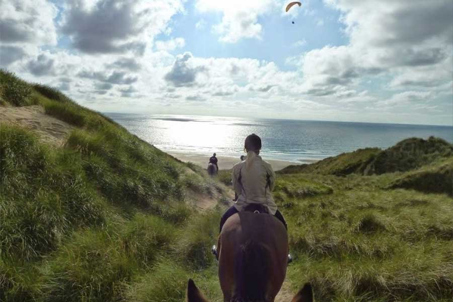 Riding horses through the dunes in Perranporth