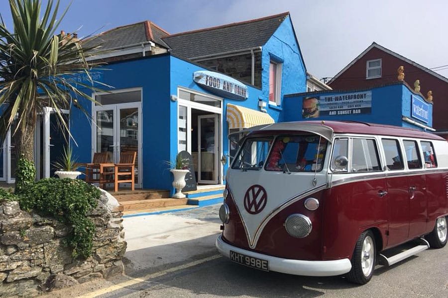 An old VW Camper van parked outside of The Waterfront in Perranporth