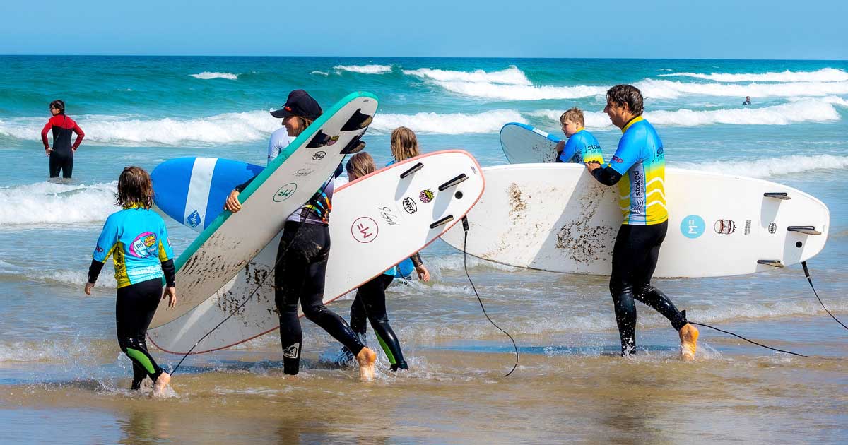 A large family heading in for a surf lesson with Stoked Surf School instructor Malo