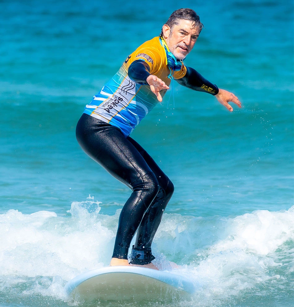 A man surfing with Stoked Surf School