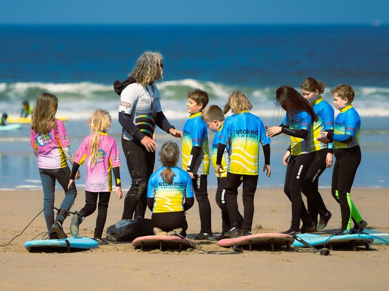 A group of kids, part of the Time2Move program, learning to surf