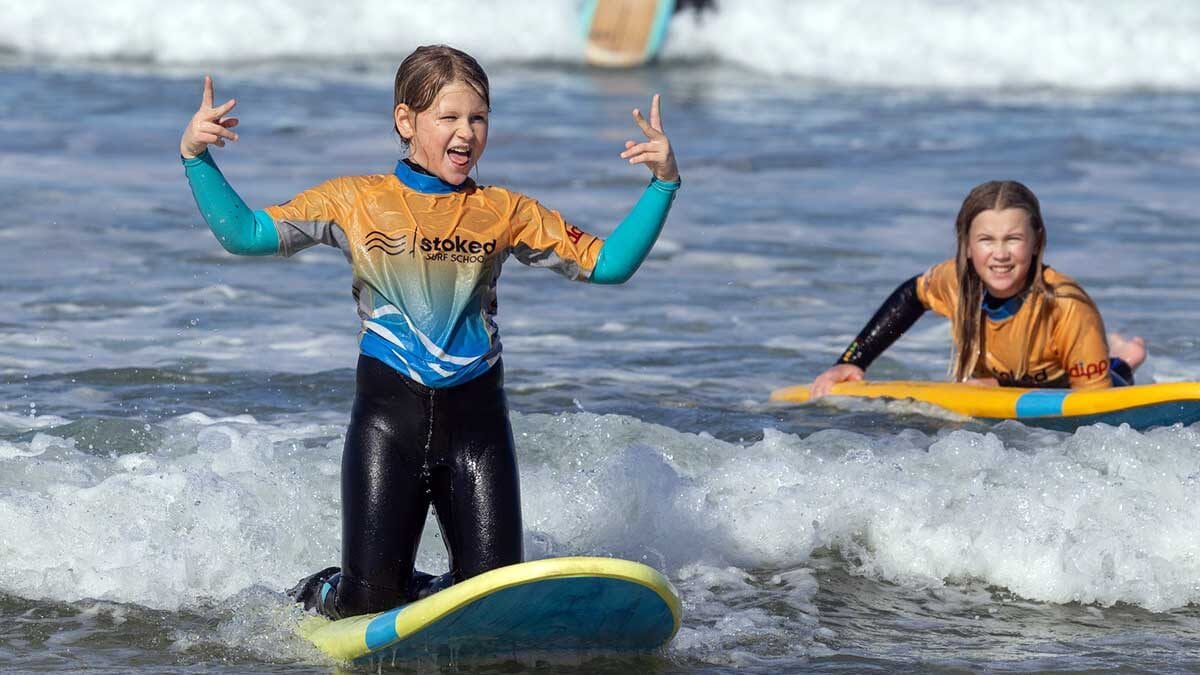 2 kids enjoying learning surfing during the October 2025 half term holiday