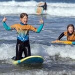 October 2025 Half Term Offer 5 2 kids enjoying learning surfing during the October 2025 half term holiday