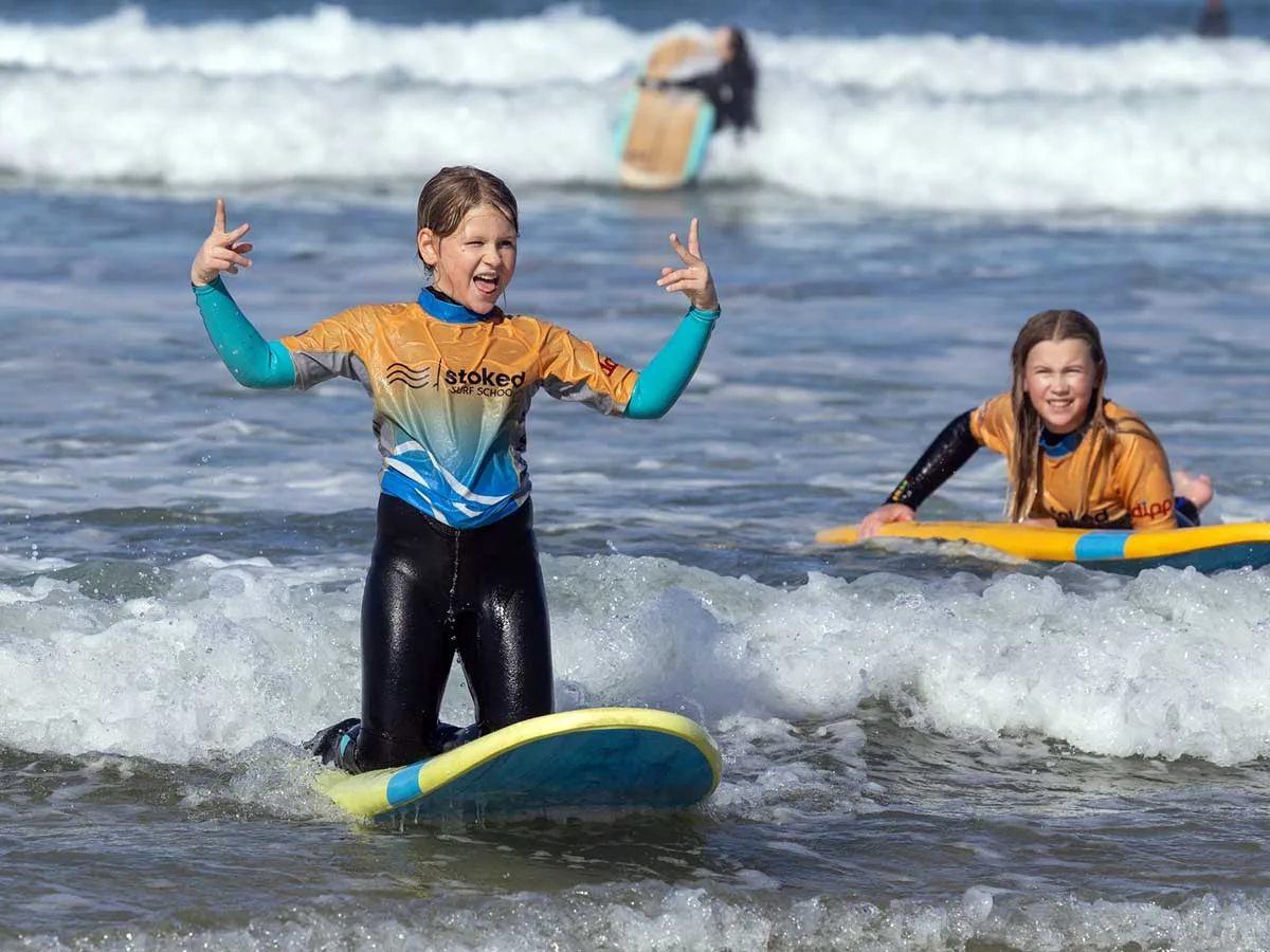 2 kids enjoying learning surfing during the October 2025 half term holiday