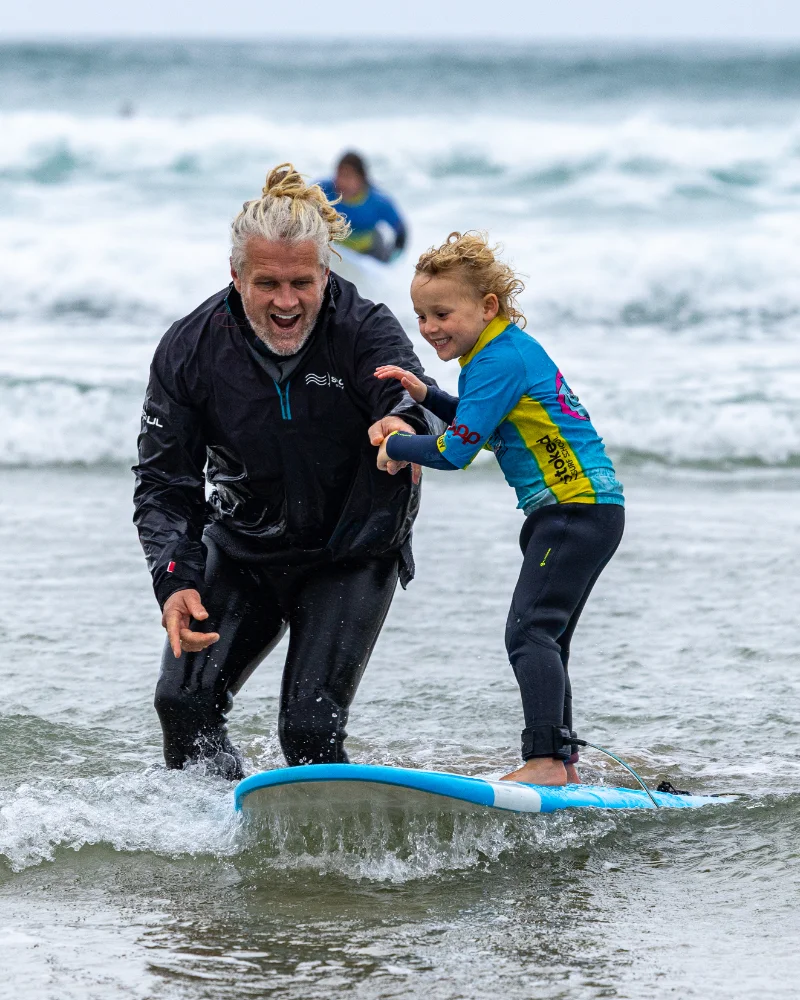 Head coach Ju teaching a young child how to surf