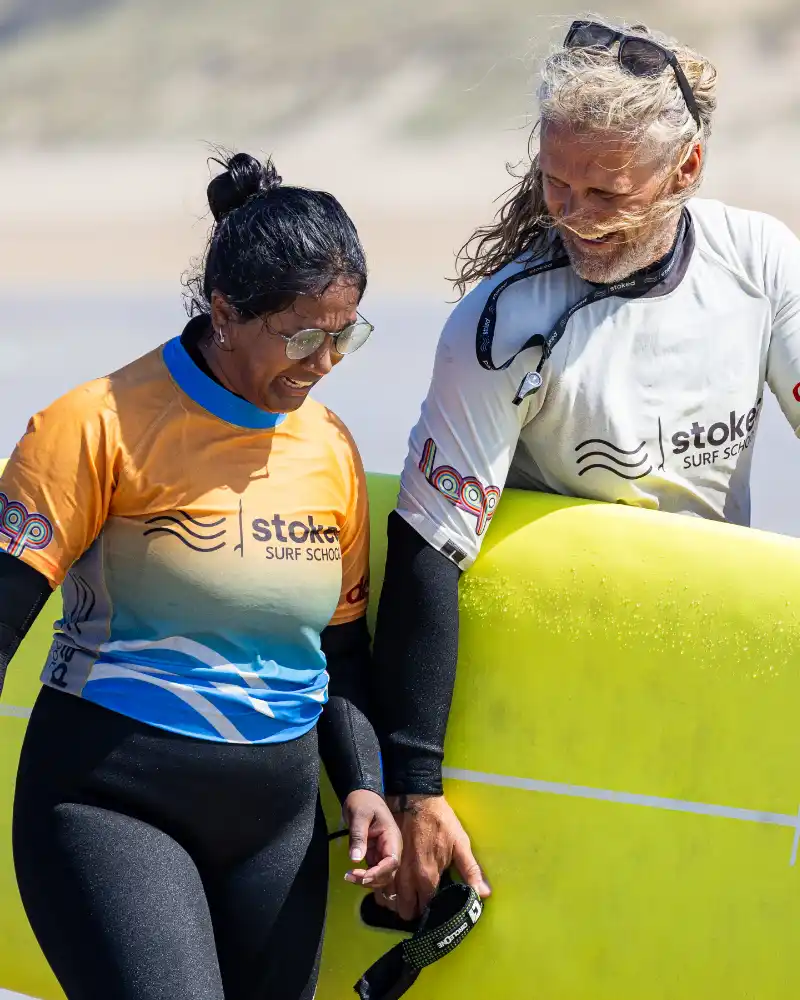 Julian and someone taking a surf lesson