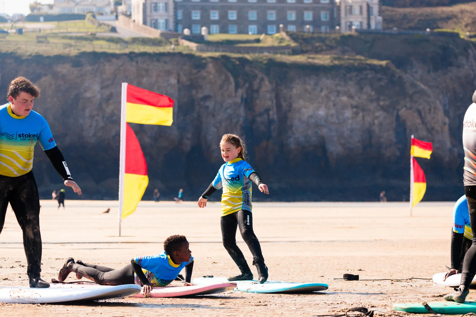 A surf lesson on the sand at Perranporth with the cliffs behind